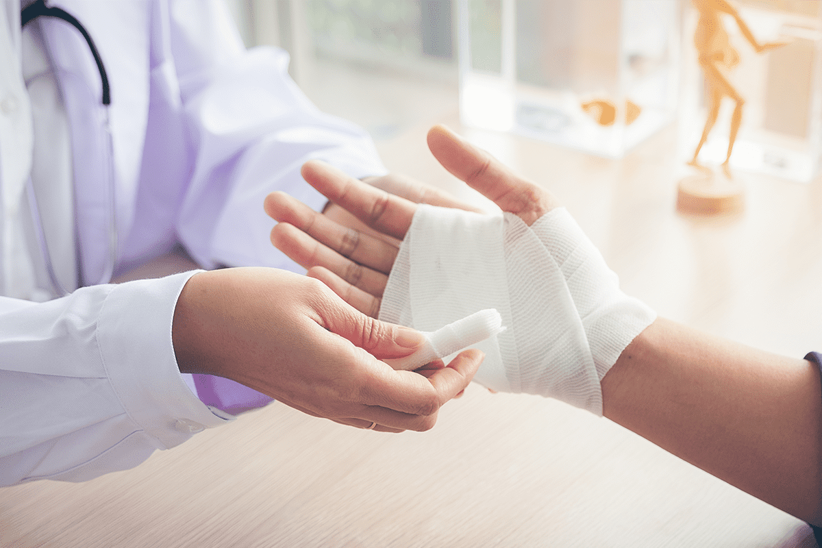 An injured hand is wrapped in a clean, white bandage.
